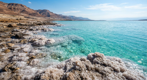 Turquoise water and sparkling salt crystals on the shore of the Dead Sea